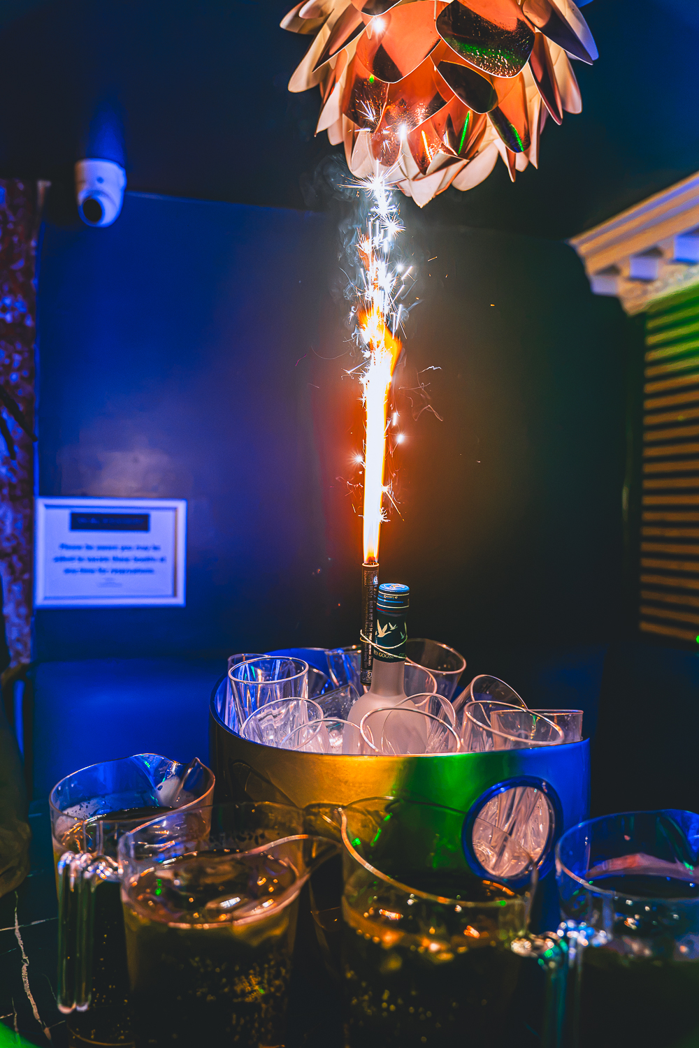 A VIP booth at The Foyer with an ice bucket, drinks and a champagne sparkler