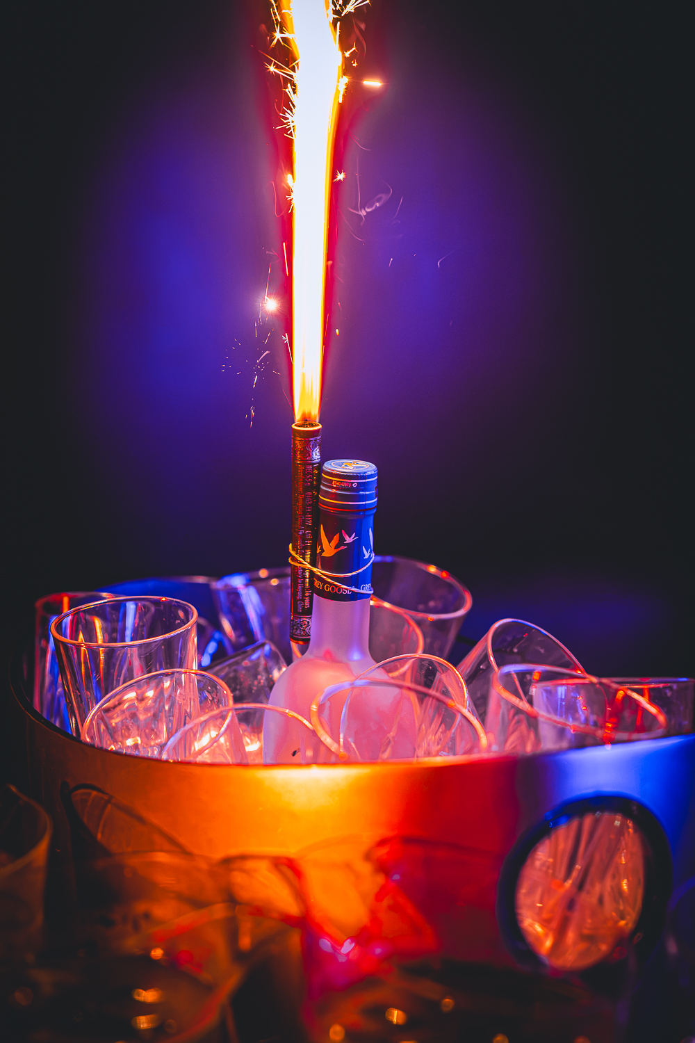 Champagne with a lit bottle sparkler in a VIP booth